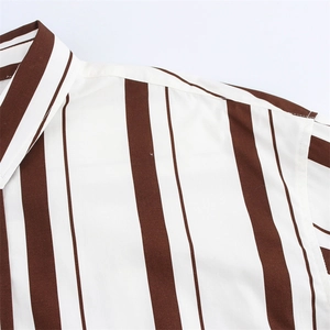 Detalle del cuello y costura del hombro en una camisa de rayas marrones y blancas