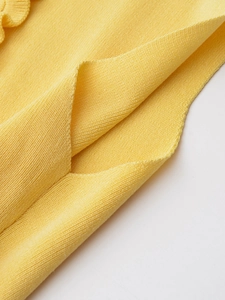 Detailed macro view of bright yellow fine knit fabric texture with soft wavy edge design
