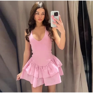 Detail view of pink halter V-neck dress featuring layered ruffle hem and elastic fabric