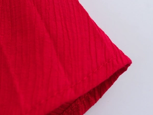 Close-up of red ribbed fabric texture and fine single-needle stitching detail