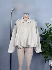 Detailed view of beige faux suede cropped bomber jacket with elasticated hem and lapel collar