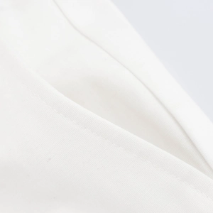 Makroaufnahme von weißem Baumwollstoff mit präzisen Nähten an der Tasche des Kleidungsstücks