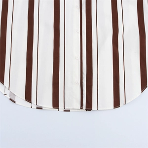 Detalle de camisa de popelina a rayas con botones de resina blancos y dobladillo curvo