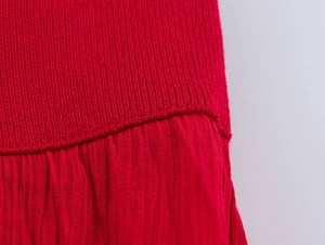 Detailed macro view showing red ribbed knit fabric and pleated textile texture quality