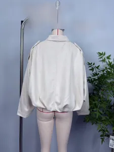 Detail view of the back of a beige suede bomber jacket featuring cargo style and elastic hem
