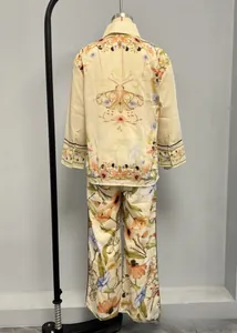 Detail of loose beige pajamas with vintage moth and floral print in two-piece set style
