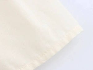 Detail view of beige fabric showing smooth plain weave texture and double stitching seams