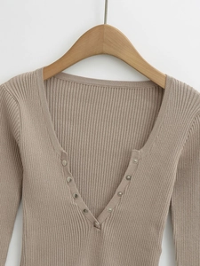 Detail of V-neck ribbed knit cardigan with elegant silver metal button fasteners