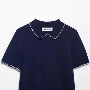 Haut en tricot bleu marine à col en V avec bordures festonnées blanches aux manches