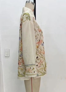 Detailed view of floral print blouse featuring contrast black piping on the cuffs