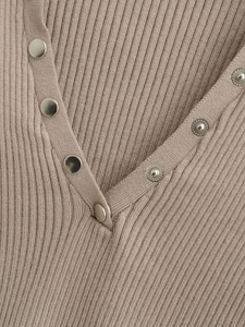 Close-up of ribbed knit texture and metallic snap buttons on the V-neck cardigan