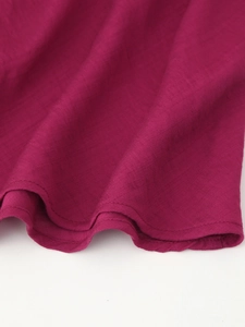 Dettaglio dell'abito rosso con scollo all'americana in cotone e lino con doppie cuciture