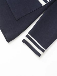 Close-up of navy knit blazer sleeve featuring dual white stripes and premium stitching