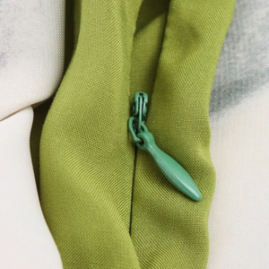 Close-up of high-quality green invisible zipper on the sleeveless midi dress fabric