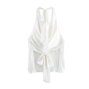 Detail showing the luxurious satin texture and large bow tie on white halter neck top