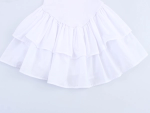 Detail of white double-layered ruffled hem with lightweight cotton fabric texture