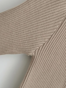 Close-up detail of the durable ribbed knit stitching and khaki fabric on a women cardigan