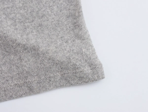 Primo piano del tessuto in maglia grigio melange con dettagli di cucitura a doppio ago