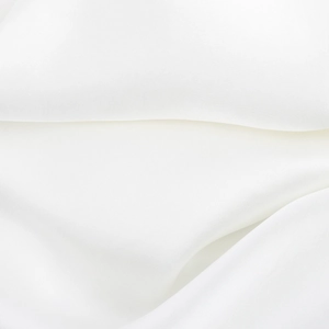 Close-up of white satin fabric showing luxurious silky texture and soft elegant drapes
