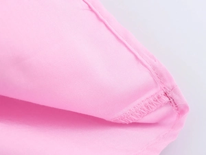 Detailed macro view showing pink sleeveless dress fabric texture and professional stitching