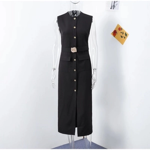 Détail d'une robe midi noire sans manches avec boutons dorés et ceinture à boucle