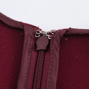 Detailed macro view of the YKK invisible zipper and metal hook on the maroon midi dress