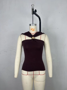 Detail of knit halter top with gold ring ornament and twisted neckline in dark brown