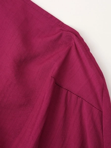Dettaglio macro del tessuto rosso in lino con cuciture raffinate sulle spalle dell'abito