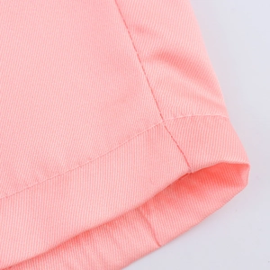 Vue détaillée du tissu en sergé de coton rose montrant la couture de l'ourlet de qualité