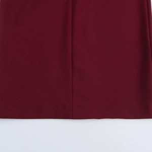 Detail view of the wine red fabric texture with a vertical seam and flat hem finish