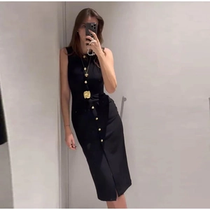 Détail de la robe midi noire sans manches avec boutons dorés et accessoires en métal