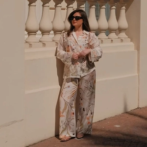 Detail view of floral print texture on the loose long-sleeve shirt and wide-leg pants set