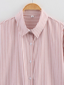 Close-up of pink striped shirt collar with white buttons and size S label detail