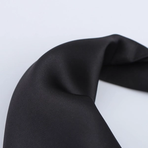 Macro shot of high-quality black satin fabric showing smooth texture and twill weave
