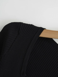 Detailed view of black ribbed knit cardigan featuring vertical texture and v-neck stitching