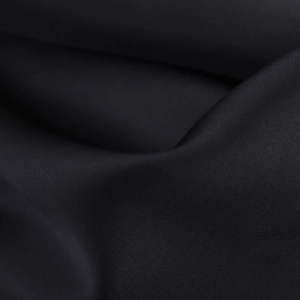 Macro shot of high-density black satin fabric showing silky texture and elegant draping