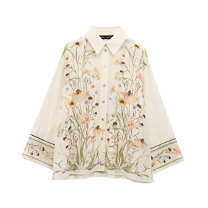 Detail of floral print shirt featuring warm toned flowers and pearl button closure