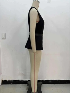 Détail d'un gilet noir sans manches avec ceinture fine et boucle métallique dorée