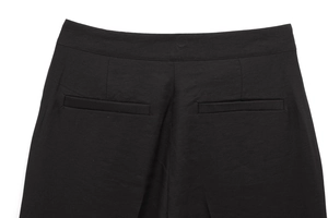 Dettaglio posteriore dei pantaloni neri con cinturino e tasche a filetto posteriori