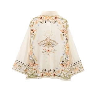 Close-up of vintage moth illustration and floral patterns on beige linen shirt back