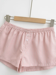Detailed close-up of pink and white gingham shorts with elastic waist and white buttons