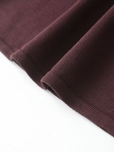 Macro shot of fine knit fabric in deep burgundy showing soft texture and premium quality