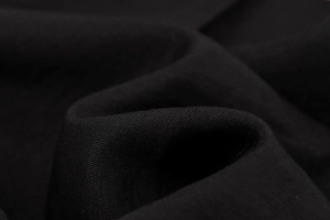 Vista macro della trama del tessuto nero intrecciato di qualità sui pantaloni larghi