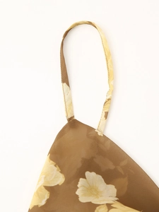 Detail shot of thin adjustable straps on brown floral chiffon dress with light fabric texture