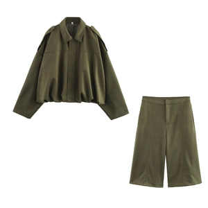 Flat lay of olive green utility jacket and shorts set with epaulettes and pleated details