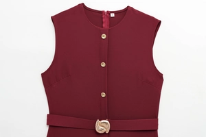 Détail de la robe sans manches bordeaux avec boutons dorés et ceinture à la taille