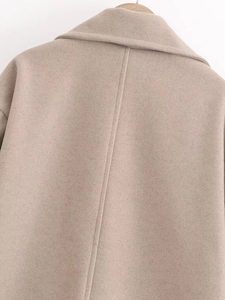 Vue macro détaillée de la texture du manteau en laine beige et des coutures du dos