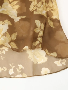 Close-up of floral print chiffon fabric showing delicate hem stitching and sheer texture