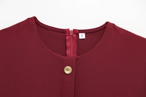 Détail d'une robe midi bordeaux avec col rond, bouton doré et fermeture éclair au dos