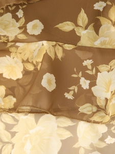 Detail of floral chiffon fabric with ruffles on a vintage French brown summer dress